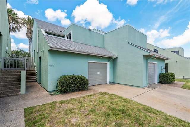 14300 Aloha St Unit 134, Corpus Christi, TX 78418 - view of front of property featuring stucco siding, concrete driveway, roof with shingles, and a garage