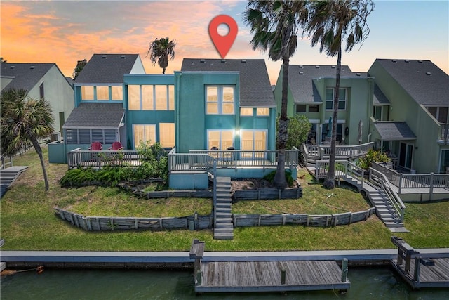14300 Aloha St Unit 134, Corpus Christi, TX 78418 - back of house at dusk with stucco siding, a residential view, and a deck with water view
