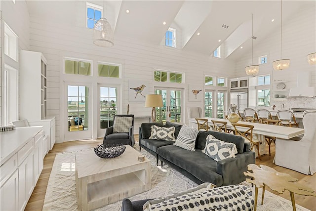 living room featuring light hardwood / wood-style flooring and a high ceiling