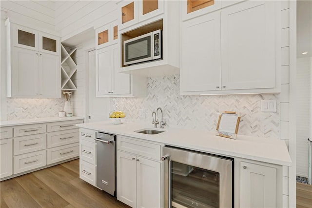 kitchen featuring wine cooler, sink, and white cabinets