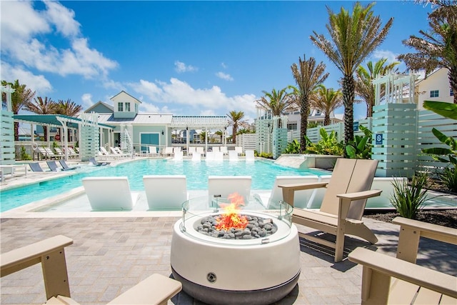 view of pool with a fire pit, a patio area, pool water feature, and a pergola