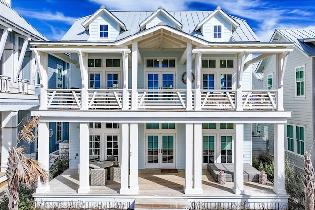 back of house with an outdoor living space, a balcony, a deck, and french doors