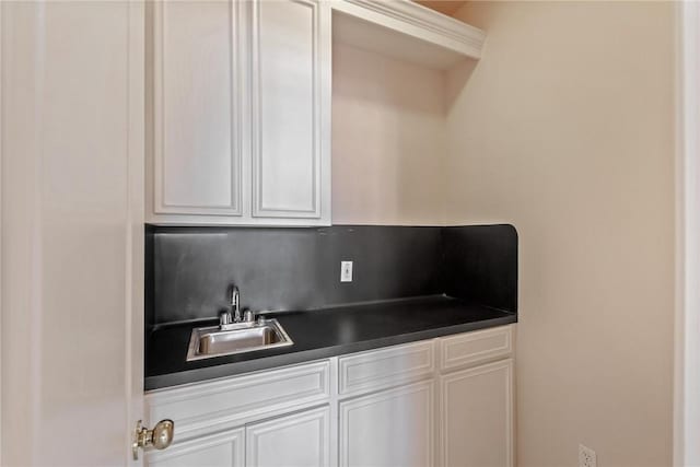 13534 Bullion Ct, Corpus Christi, TX 78418 - kitchen with a sink, dark countertops, and white cabinetry