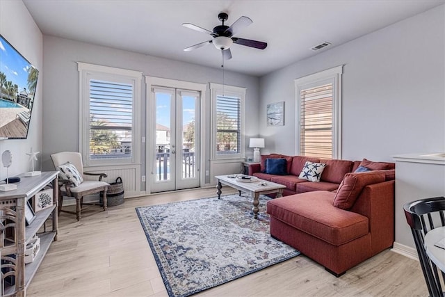 living room featuring ceiling fan, french doors, and light hardwood / wood-style floors