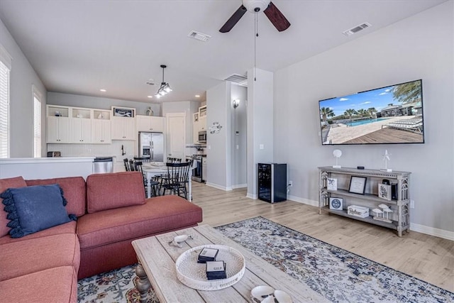 living room featuring ceiling fan and light hardwood / wood-style floors