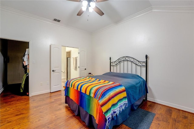 bedroom featuring ensuite bathroom, ornamental molding, vaulted ceiling, ceiling fan, and wood-type flooring