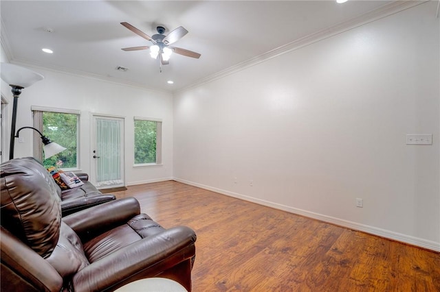 living room with light wood-type flooring, ceiling fan, and crown molding