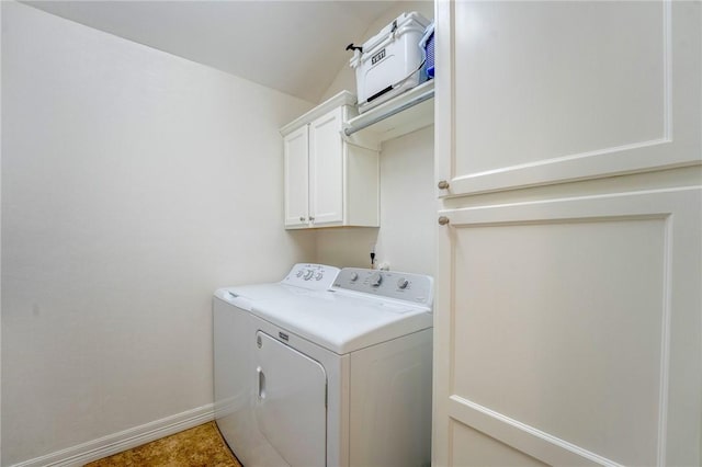 washroom featuring cabinets and washer and clothes dryer