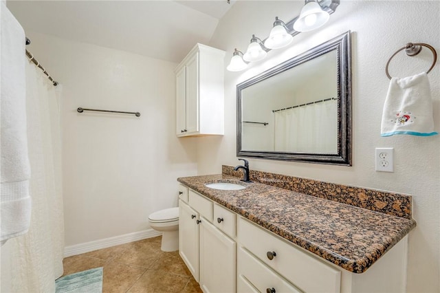 bathroom with tile patterned floors, vanity, toilet, and vaulted ceiling