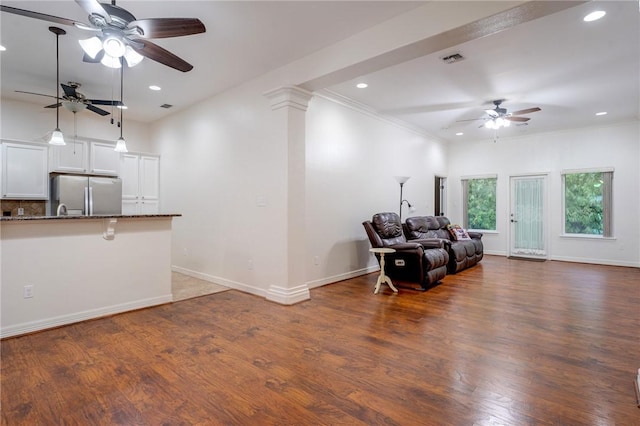 living room with ceiling fan, dark hardwood / wood-style flooring, and ornamental molding