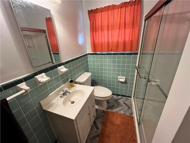 bathroom with toilet, vanity, tile walls, and walk in shower