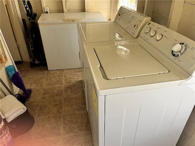 washroom with separate washer and dryer and dark tile patterned floors