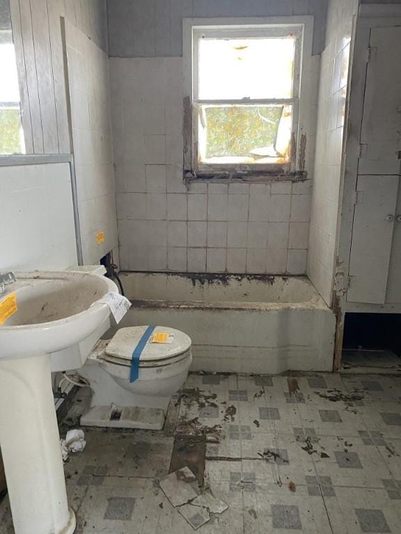 bathroom featuring a tub and toilet