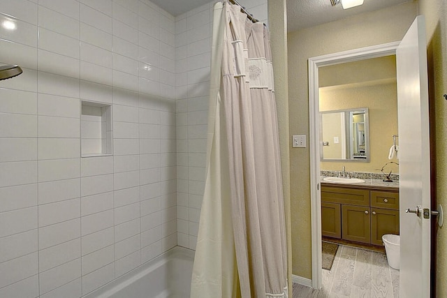 bathroom with wood-type flooring, vanity, and shower / tub combo