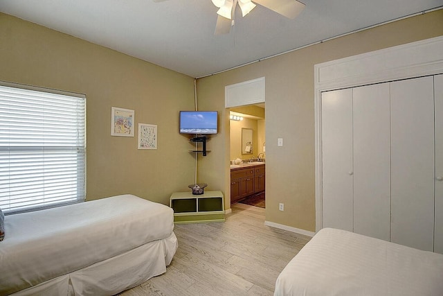 bedroom with a closet, light wood-type flooring, ceiling fan, and ensuite bathroom