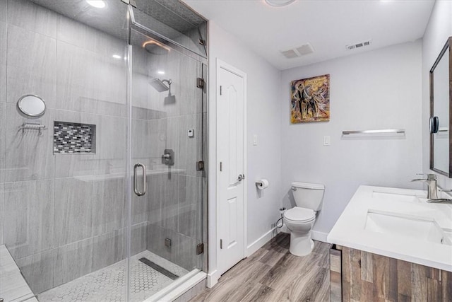 full bath with toilet, wood finished floors, visible vents, and a stall shower