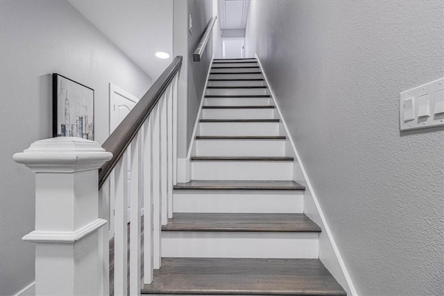 staircase featuring a textured wall