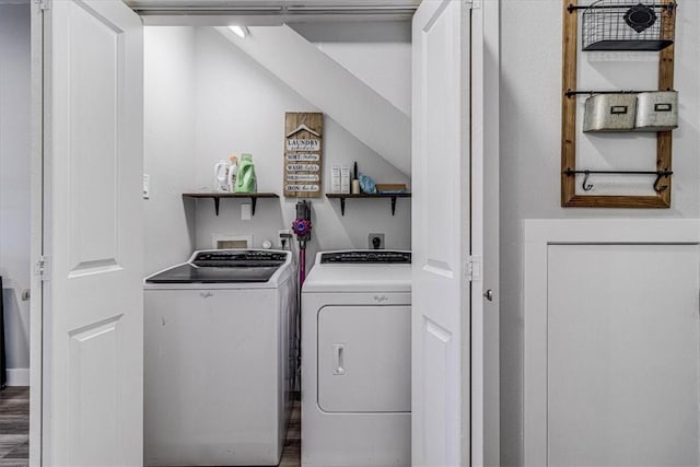 washroom featuring laundry area, wood finished floors, and washing machine and dryer