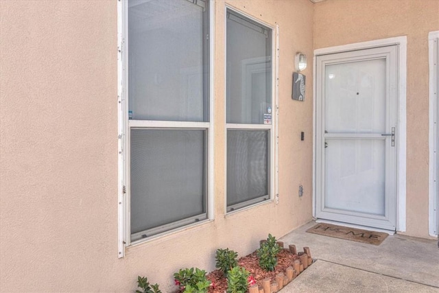 doorway to property featuring stucco siding