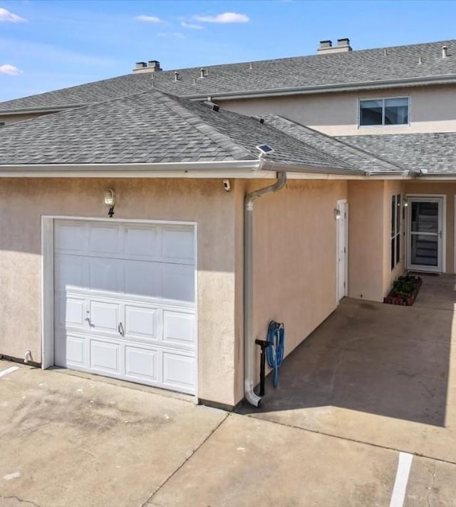 15433 Seamount Cay Ct Unit 4, Corpus Christi, TX 78418 - view of home's exterior with roof with shingles, stucco siding, concrete driveway, and a chimney