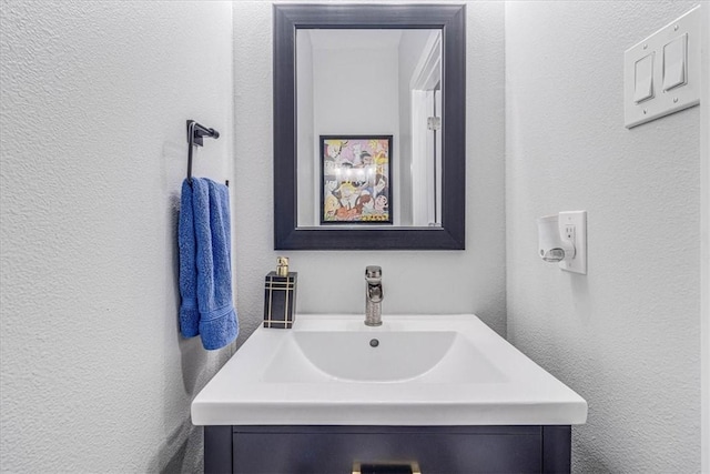 bathroom featuring vanity and a textured wall