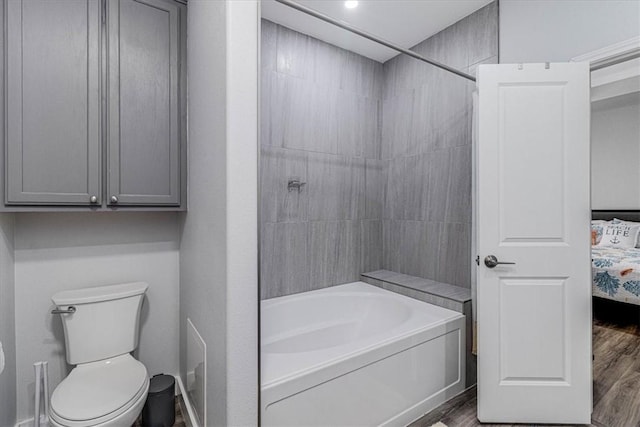 full bath featuring shower / washtub combination, toilet, ensuite bathroom, and wood finished floors