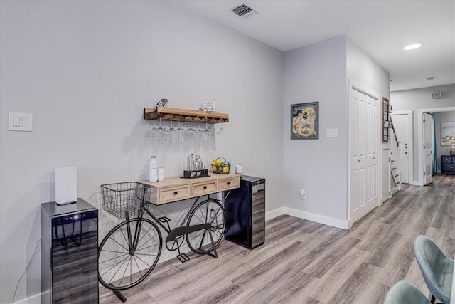 hallway with visible vents, beverage cooler, light wood-style flooring, recessed lighting, and baseboards