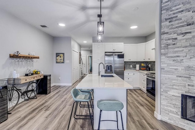 kitchen with a sink, visible vents, appliances with stainless steel finishes, and light wood finished floors