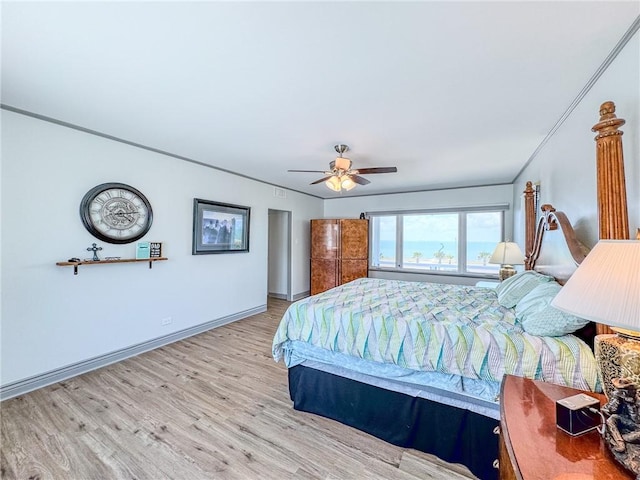 bedroom featuring ceiling fan, light wood-type flooring, and crown molding