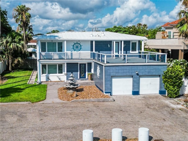 view of front of property with a front lawn, a garage, and a balcony