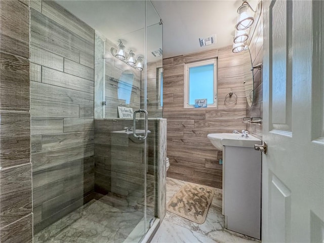 bathroom featuring a shower with shower door and vanity