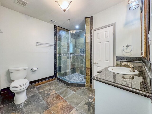 bathroom with toilet, vanity, and walk in shower