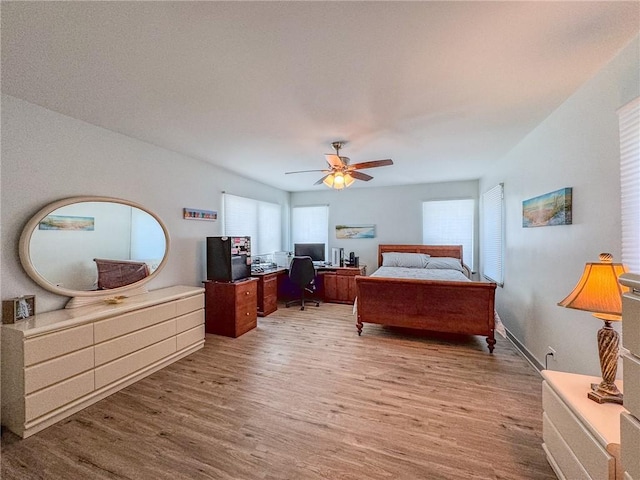 bedroom featuring ceiling fan, multiple windows, and hardwood / wood-style floors