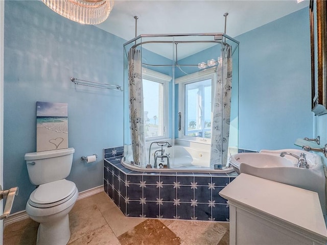 bathroom with toilet, vanity, and a relaxing tiled tub