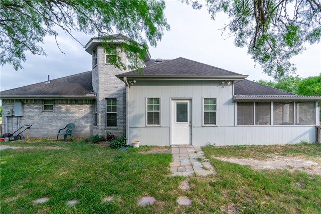 back of house with a sunroom and a yard