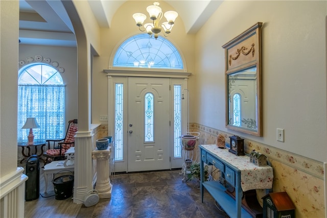 entrance foyer with a chandelier and tile walls