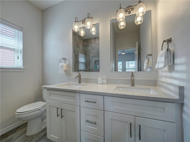 bathroom with vanity, hardwood / wood-style flooring, toilet, and walk in shower