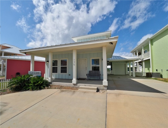 view of front of house with a carport, cooling unit, and covered porch