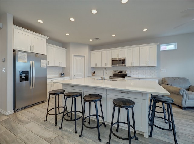 kitchen with white cabinets, light wood-type flooring, sink, and appliances with stainless steel finishes