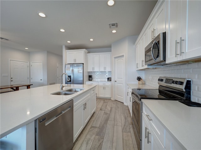 kitchen featuring white cabinets, appliances with stainless steel finishes, and sink