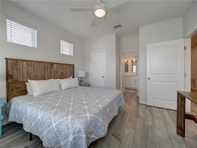 bedroom featuring connected bathroom, ceiling fan, a closet, and light hardwood / wood-style floors