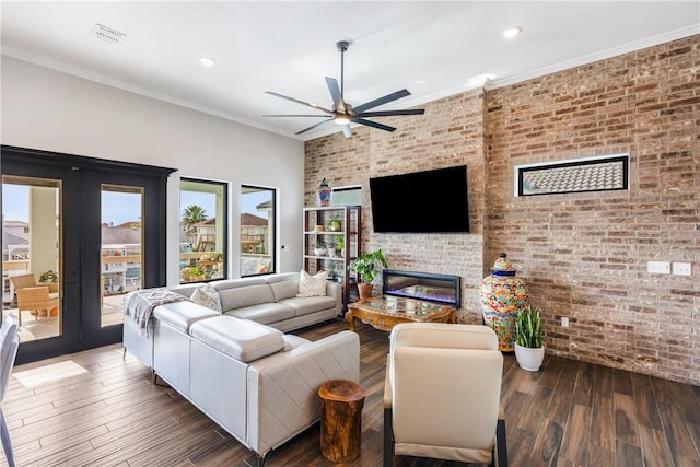 15342 Cartagena Ct, Corpus Christi, TX 78418 - living room with brick wall, ceiling fan, french doors, wood finished floors, and a glass covered fireplace