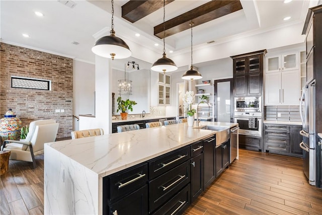 15342 Cartagena Ct, Corpus Christi, TX 78418 - kitchen featuring appliances with stainless steel finishes, a sink, a large island, hardwood / wood-style floors, and decorative backsplash