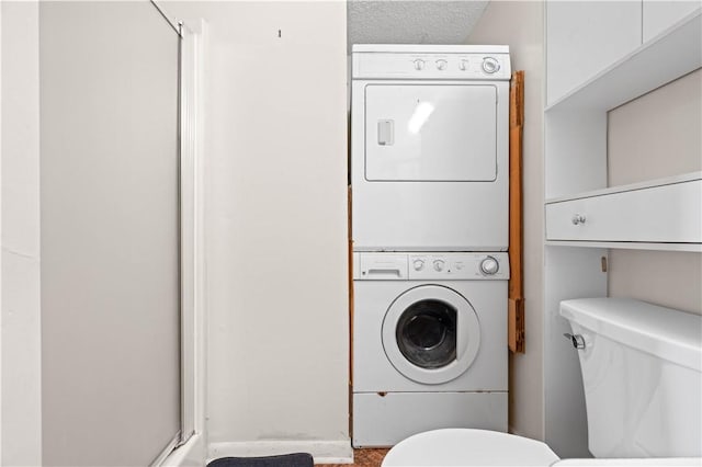 clothes washing area featuring laundry area and stacked washing maching and dryer