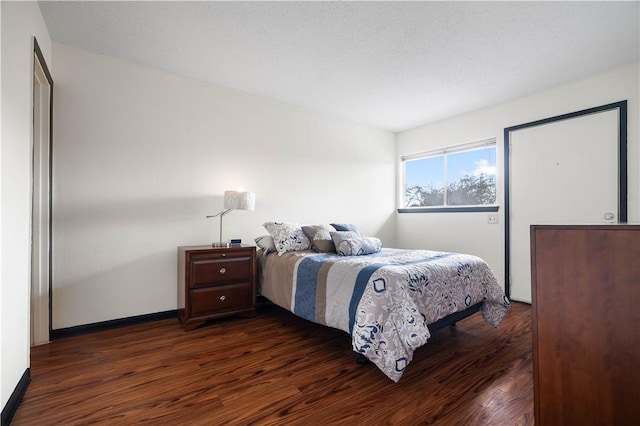 bedroom featuring dark wood-type flooring and baseboards