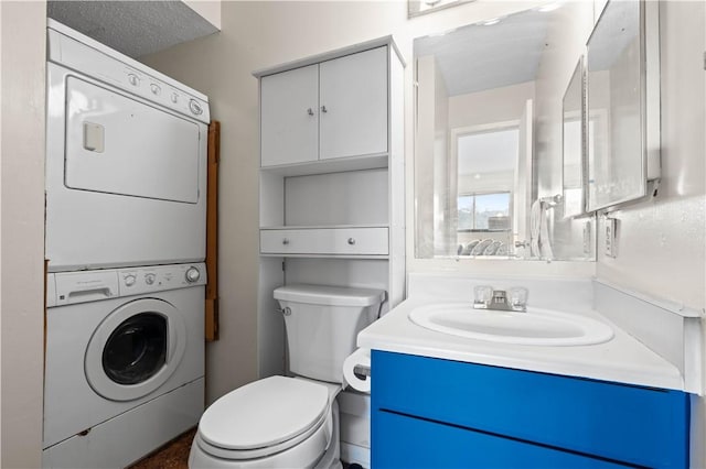 half bath with toilet, stacked washer / drying machine, and vanity