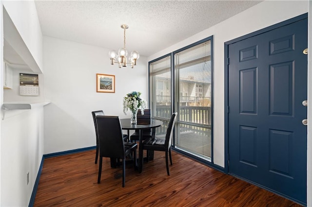 dining room with a chandelier, dark wood finished floors, a textured ceiling, and baseboards