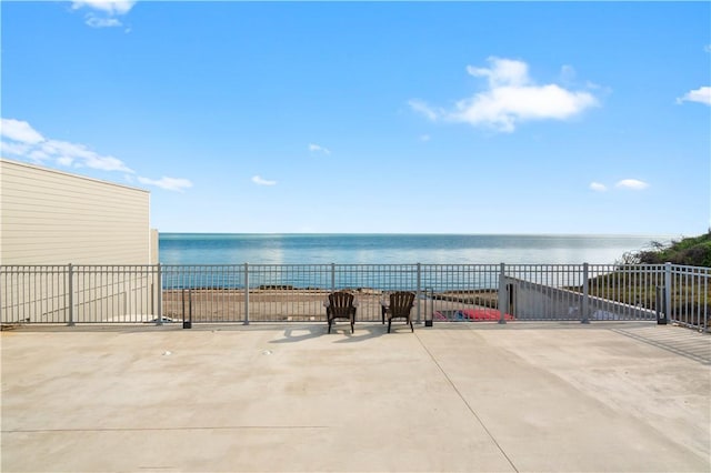 view of patio / terrace with a water view and fence