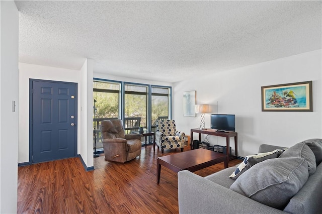 living area featuring a textured ceiling, baseboards, and wood finished floors