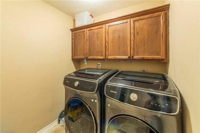 laundry room featuring tile patterned flooring, washing machine and dryer, and cabinets